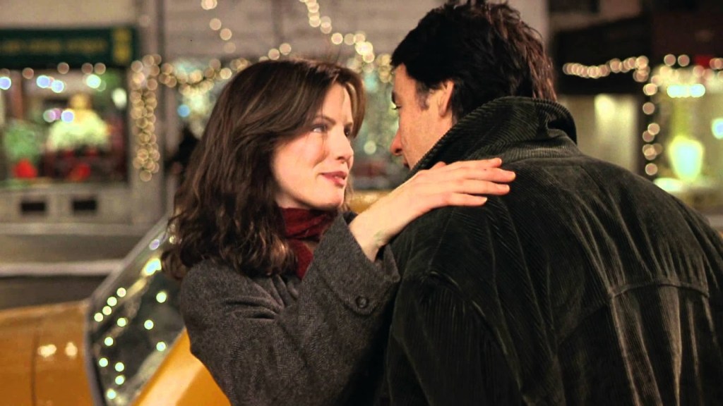 Kate Beckinsale with her hand on John Cusack’s shoulder on a New York street strung with Christmas lights.