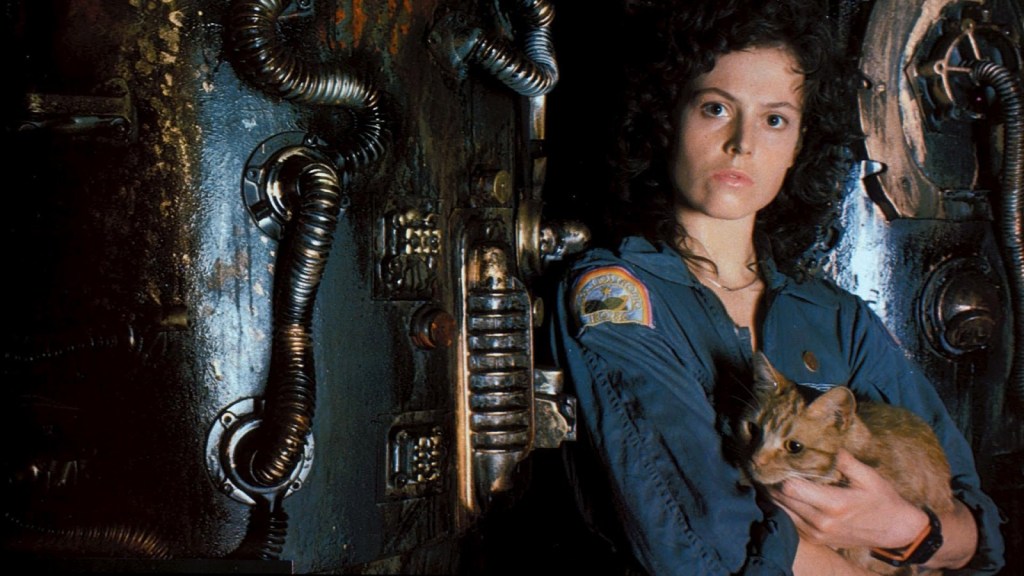 Sigourney Weaver holding an orange cat against the dark machinery of the spaceship in Alien (1979).