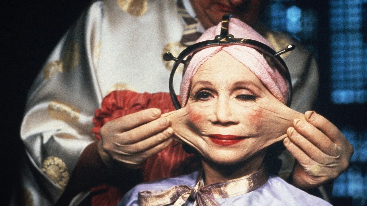 Katherine Helmond, her head wrapped in a pink towel, having the skin of her face stretched during cosmetic surgery in Brazil.