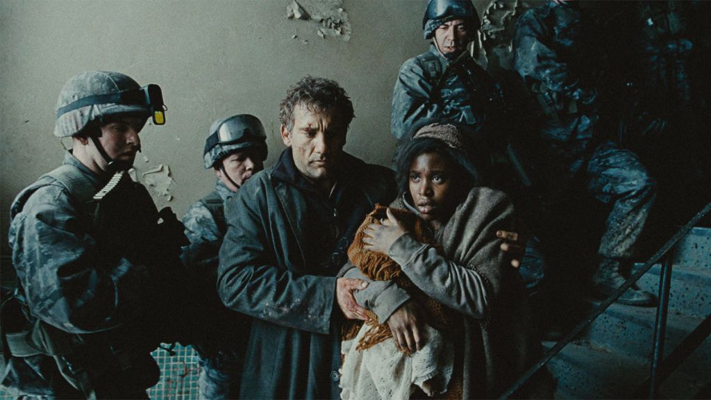 Clive Owen guiding Clare-Hope Ashitey, who is holding a baby, down a stairwell past soldiers in Children of Men.