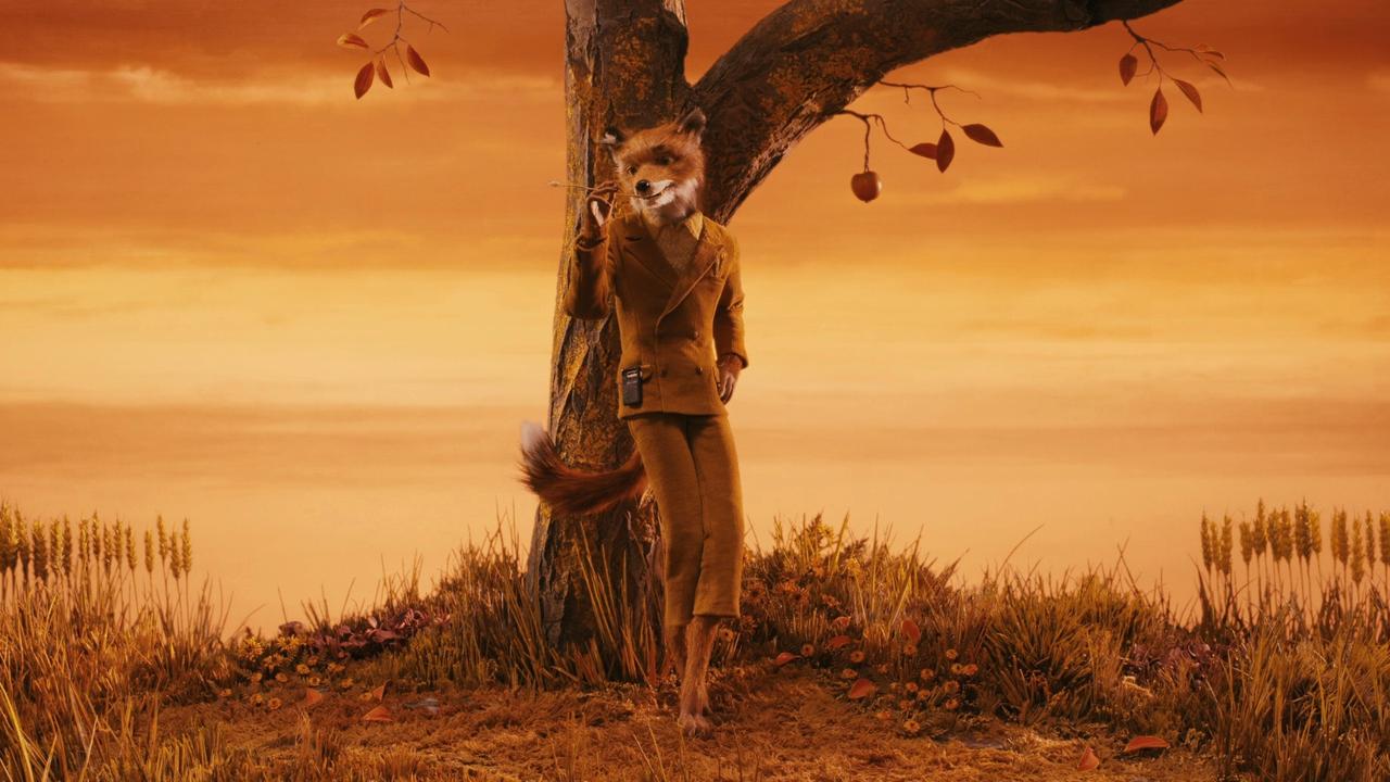 Mr. Fox in a mustard corduroy suit leaning against a tree under an orange autumn sky in Fantastic Mr. Fox.