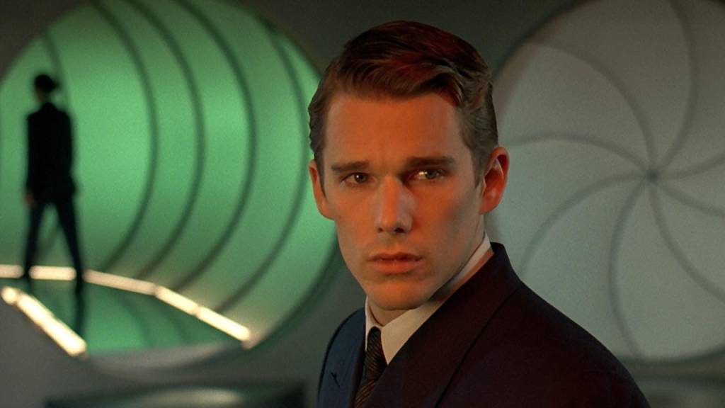Ethan Hawke in a suit, looking over his shoulder in a green-lit corridor in Gattaca.