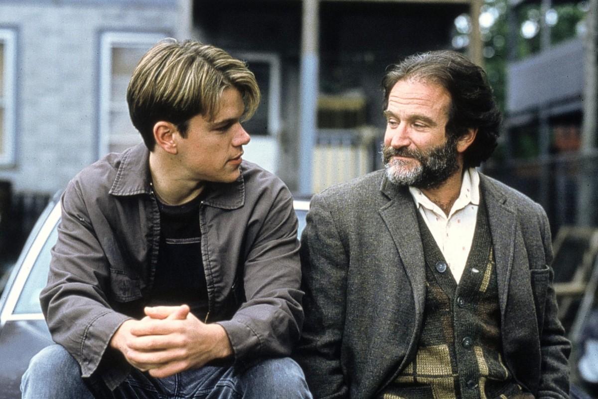 Matt Damon and Robin Williams sitting side by side on the hood of a car, talking, in Good Will Hunting.