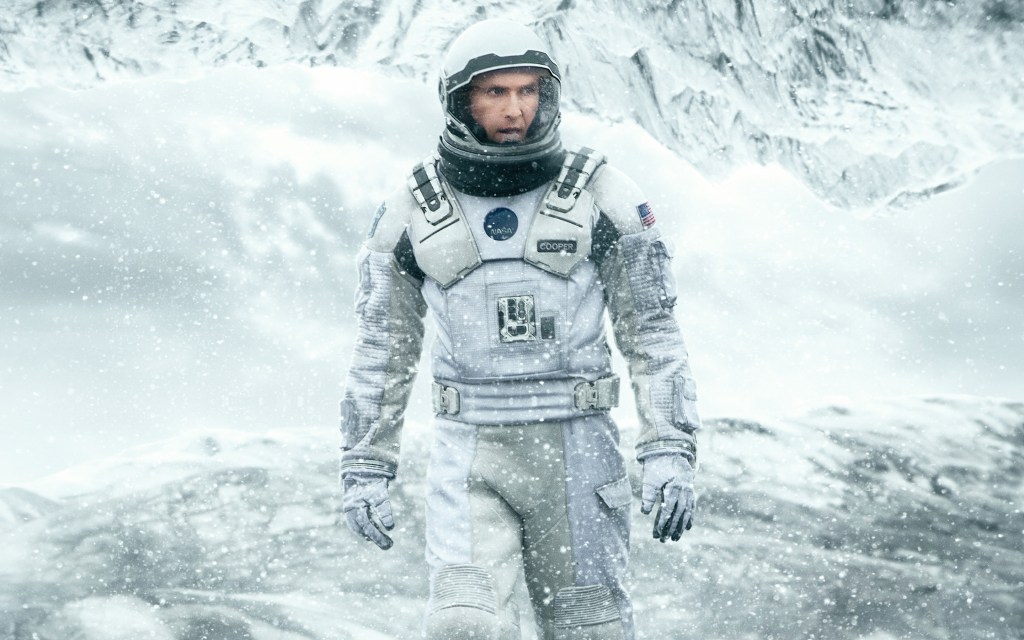 Matthew McConaughey in a white spacesuit on a snowy, frozen planet in Interstellar.